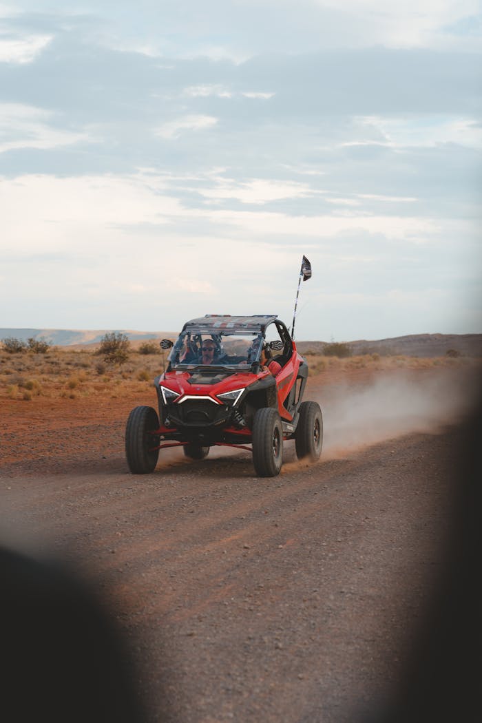 Exciting off-road ride on a dirt trail with a red buggy speeding through the arid landscape.