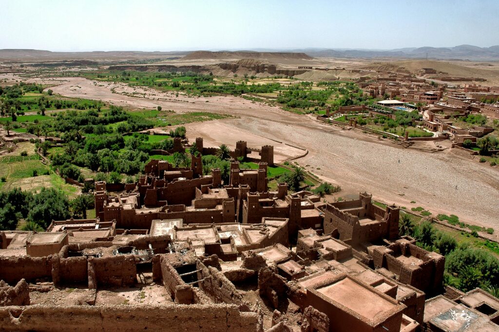 Stunning aerial view of Ouarzazate's ancient kasbahs amidst lush greenery.