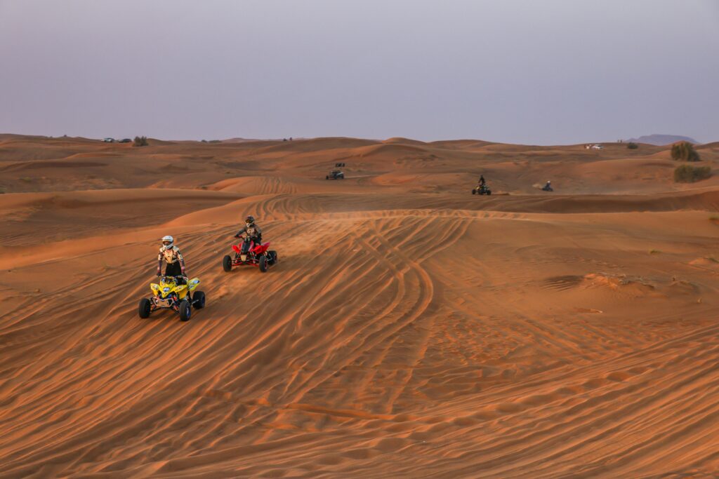 Exploring vast desert dunes on ATVs, perfect for an adrenaline-filled adventure.