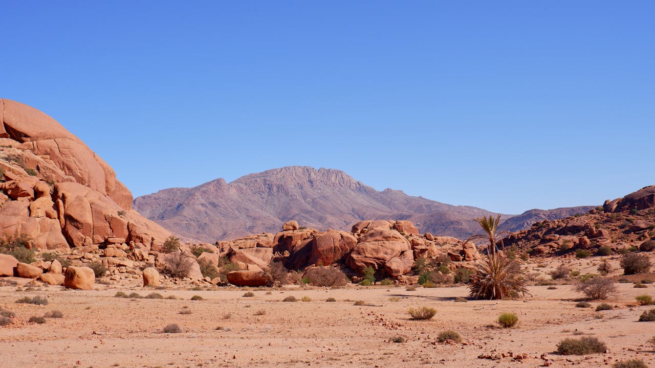 Explore the stunning red rock formations and serene desert of Tafraoute, Morocco, perfect for outdoor adventures.