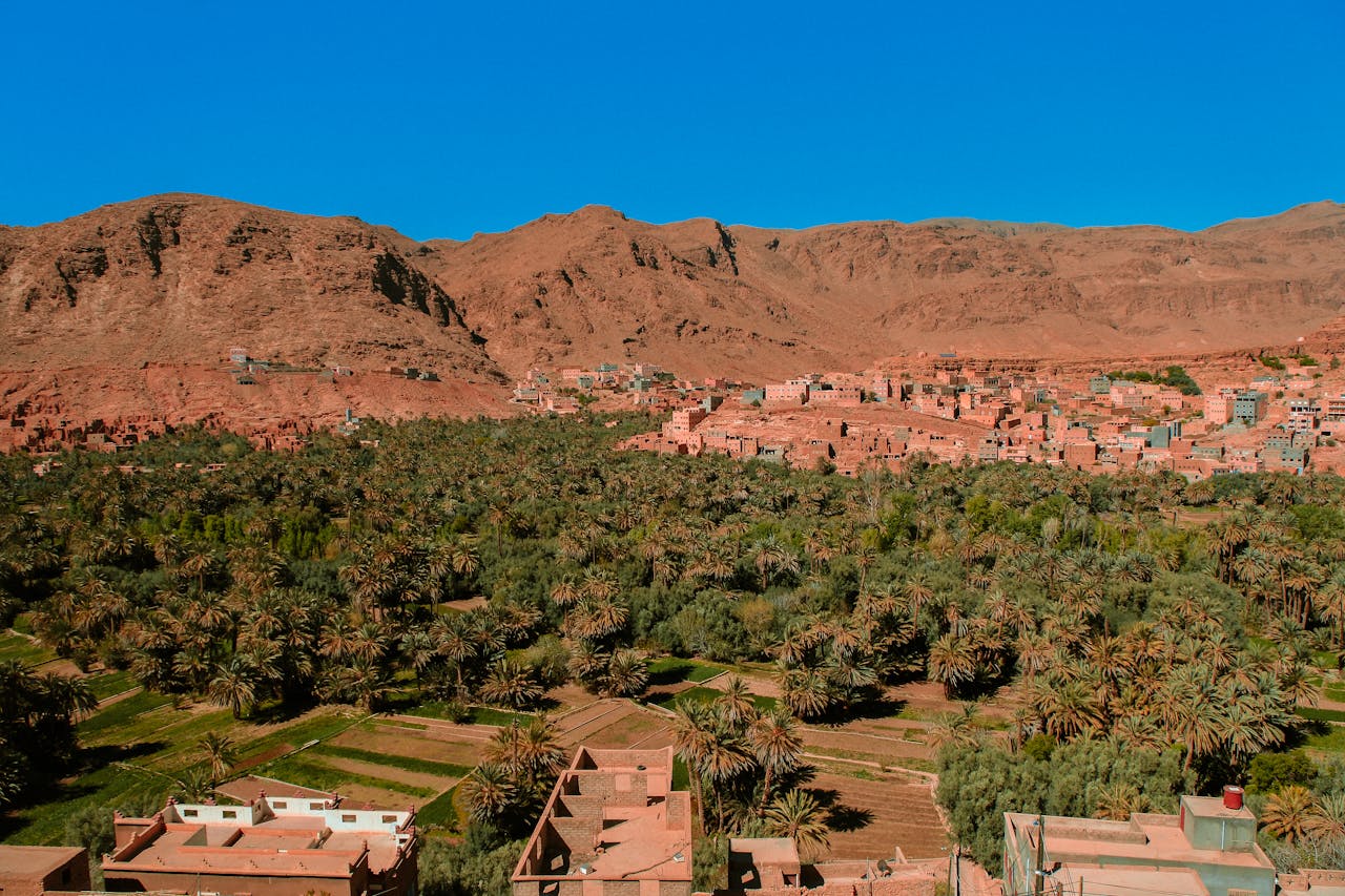 Scenic aerial view of a village nestled in the Atlas Mountains with lush greenery.