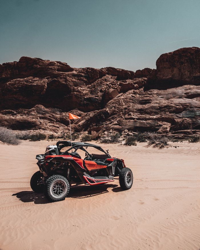 Balade Journée en buggy dans le desért d'Agafay Dune buggy navigating rocky desert terrain under clear blue sky.