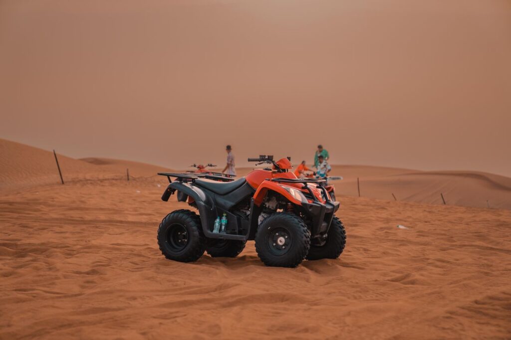Raid 2 Jours — Atlas Mountains et Désert d'Agafay Explore the thrilling experience of quad biking across vast desert sand dunes with clear skies.
